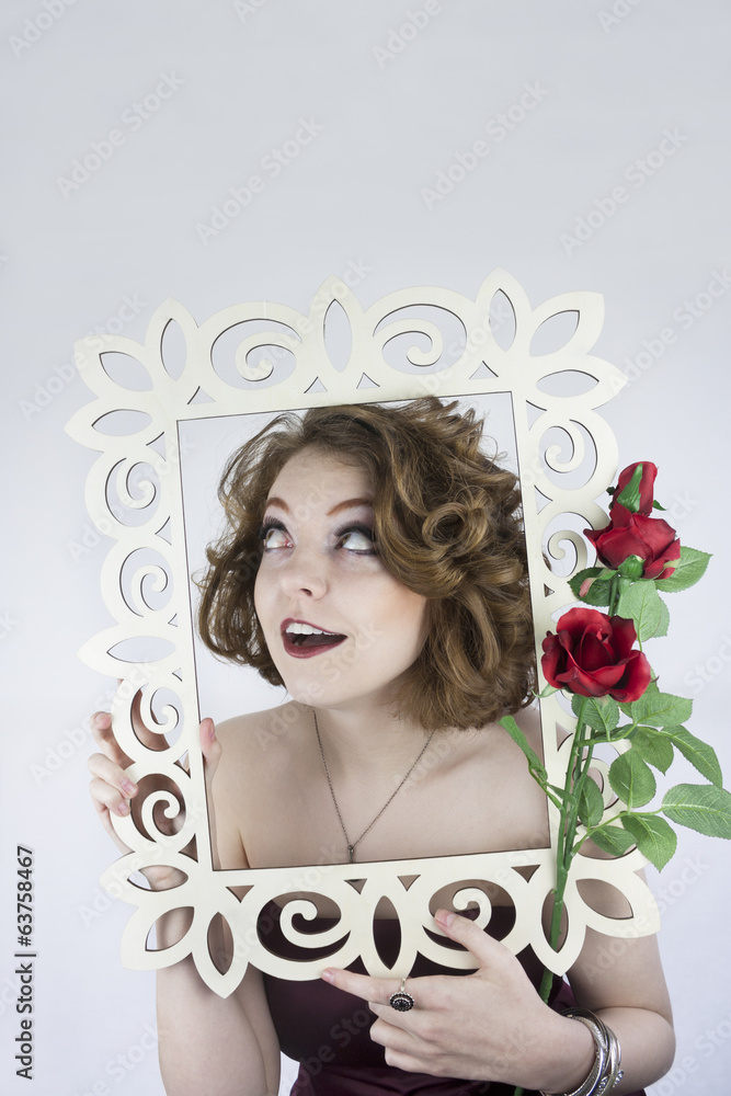 Beautiful young woman posing with white picture frame and roses.