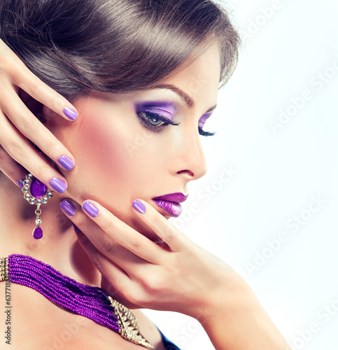 The girl with lilac makeup and manicure. Model with purple jewel