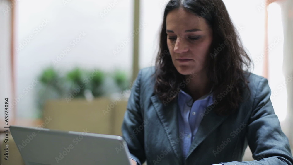 Businesswoman working on laptop in the office, steadycam shot Businesswoman working on laptop in the office, steadycam shot