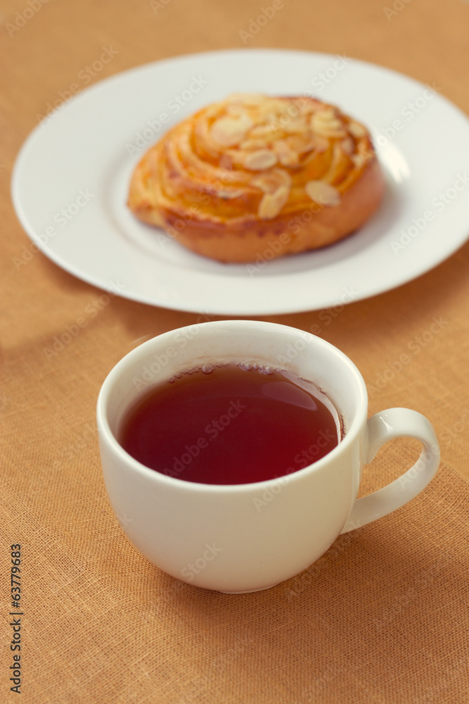 bun and cup of tea on tray bun and cup of tea on tray