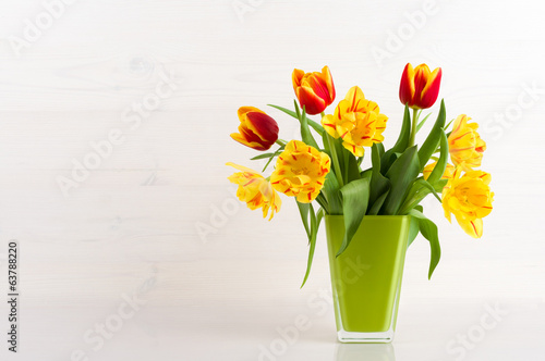Fototapeta Naklejka Na Ścianę i Meble -  Tulips in a vase on a white wooden background