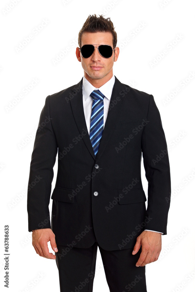 Handsome businessman standing in suit with sunglasses Handsome businessman standing in suit with sunglasses