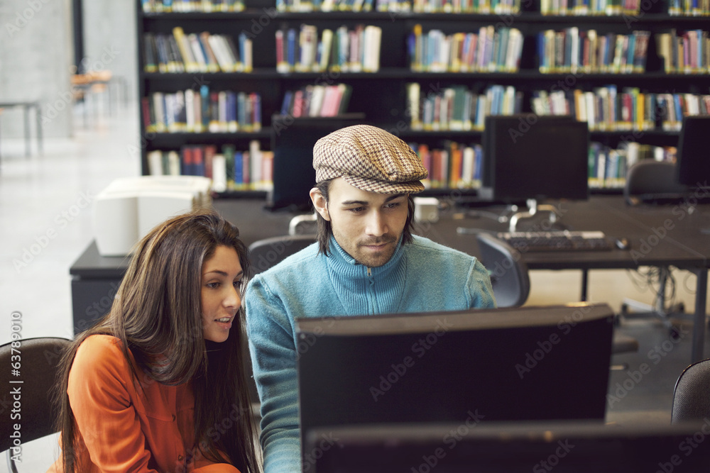 Students finding information for study on computer in library Students finding information for study on computer in library