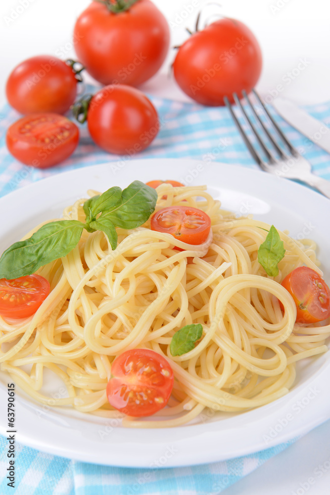 Delicious spaghetti with tomatoes on plate on table close-up Delicious spaghetti with tomatoes on plate on table close-up