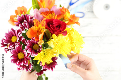 Female hands composing beautiful bouquet  close-up. Florist at