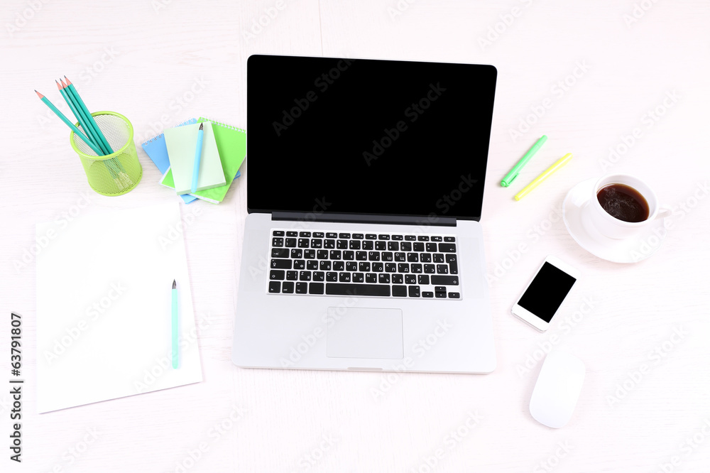Office workplace with open laptop on wooden desk Office workplace with open laptop on wooden desk