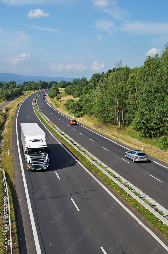 Highway passing through the countryside, truck and cars