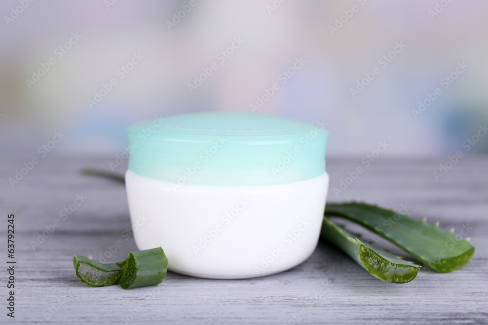 Cream and fresh green aloe leaves on wooden table Cream and fresh green aloe leaves on wooden table