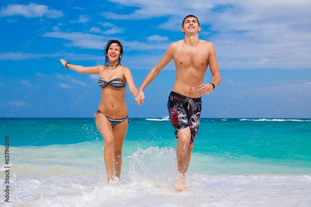 happy couple running on the beach happy couple running on the beach