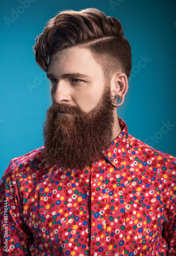 Stylish man with beard on blue background