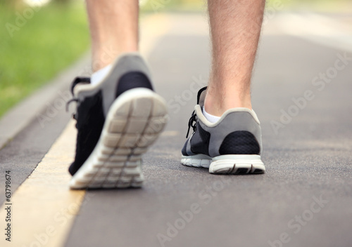 Runner feet running on road closeup on shoe 