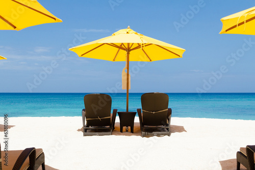 Yellow sun umbrellas and chairs on beach