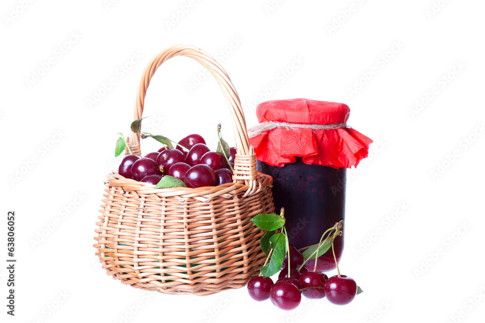 Ripe cherry in a wattled basket and bank of cherry jam Ripe cherry in a wattled basket and bank of cherry jam