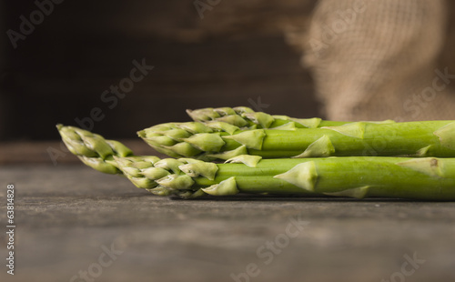 Green asparagus on old wooden background, side view