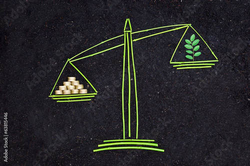 Foto Tree and money to balance scales on soil background / csr