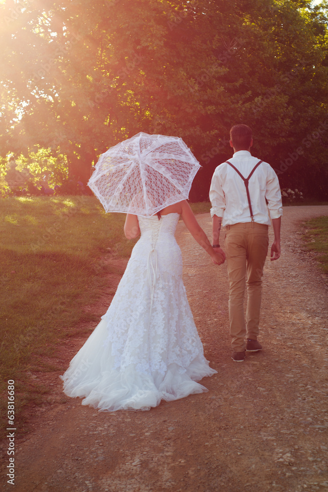 Obraz premium Bride and groom in walking off into the sunset