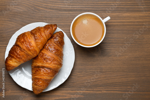 fresh croissants, cup of espresso on wooden background