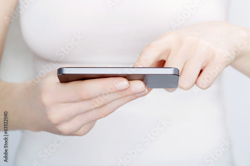 Close up of woman in white using a smartphone