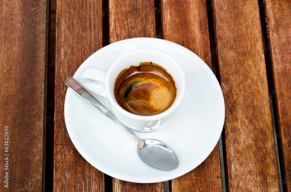 Obraz premium White espresso cup standing on the wooden table