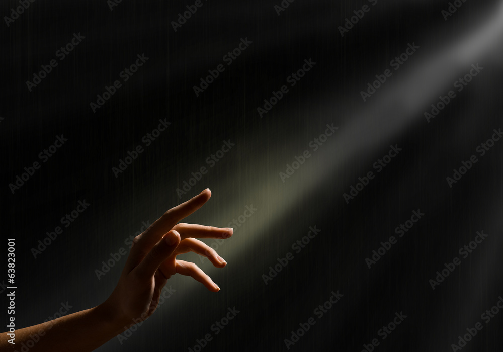 woman's hand reaches for the light rays