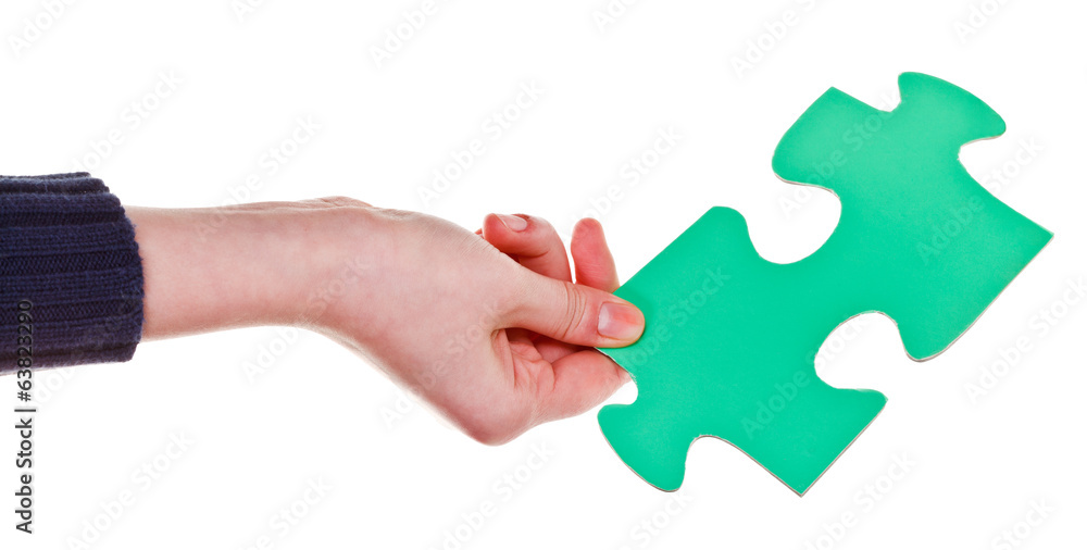 female hand holding big green paper puzzle piece female hand holding big green paper puzzle piece