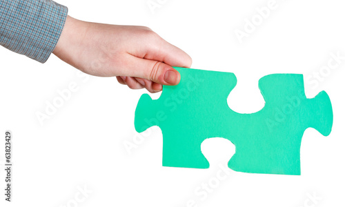 female hand holding big green paper puzzle piece