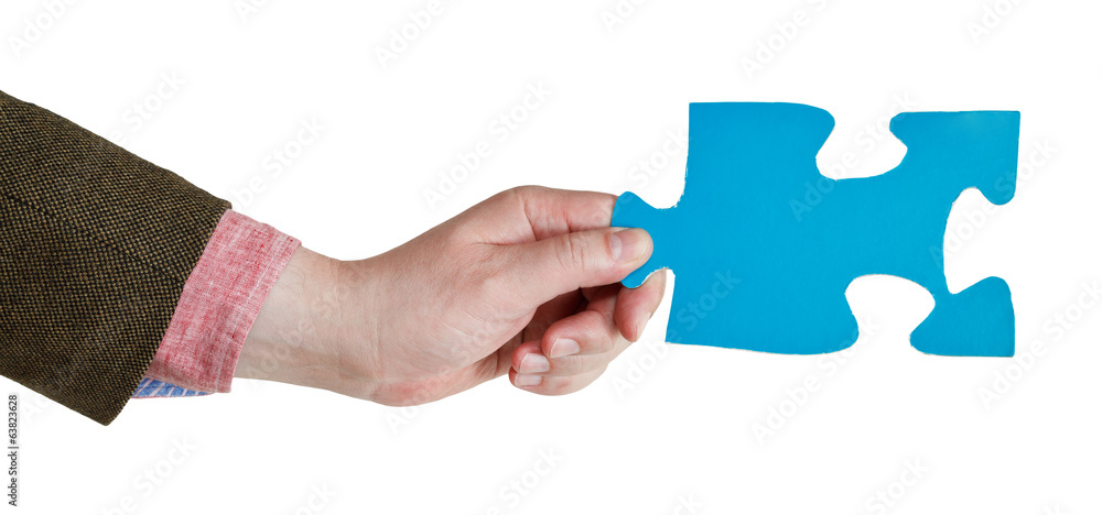 male hand holding big blue paper puzzle piece male hand holding big blue paper puzzle piece