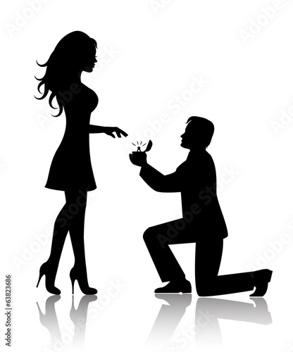 man stands on one knee and offers the woman to marry him