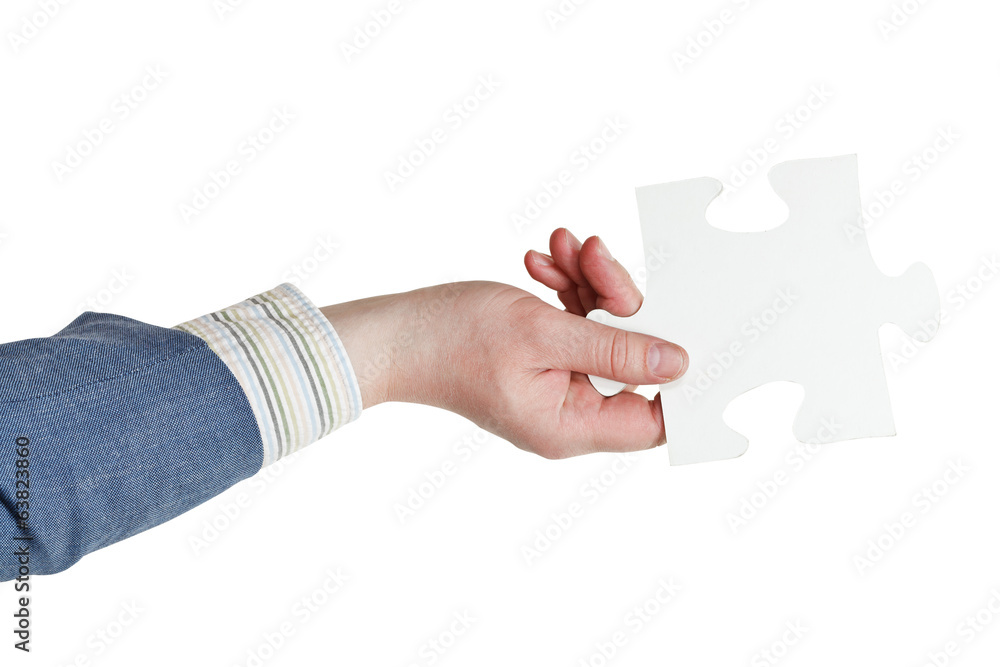 male hand holding big white paper puzzle piece male hand holding big white paper puzzle piece
