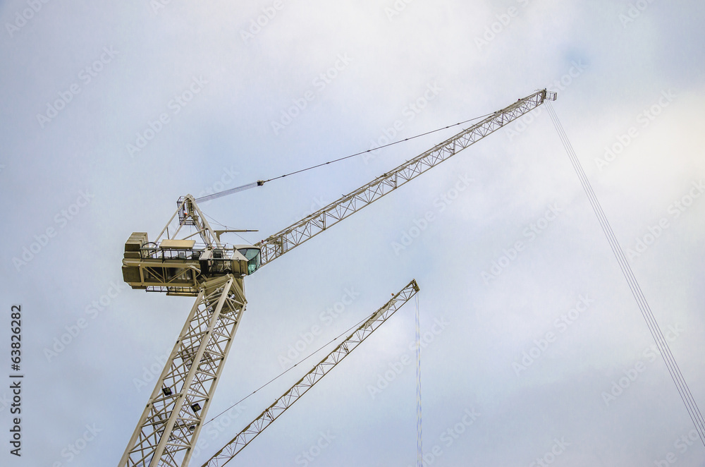Construction crane lifting load at building site