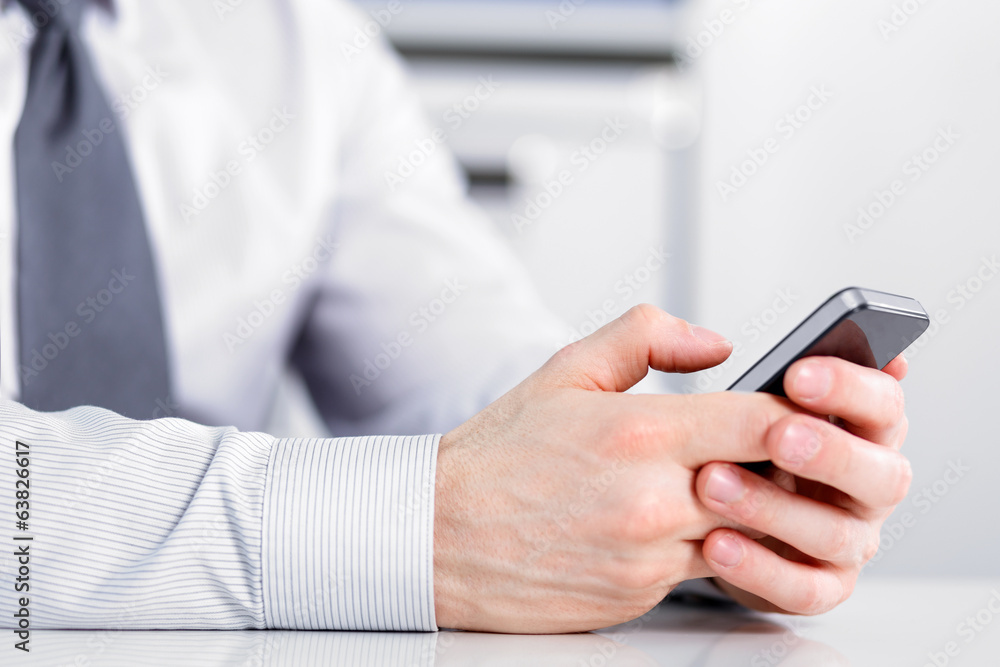 Male hand holding a cell phone and writing Male hand holding a cell phone and writing