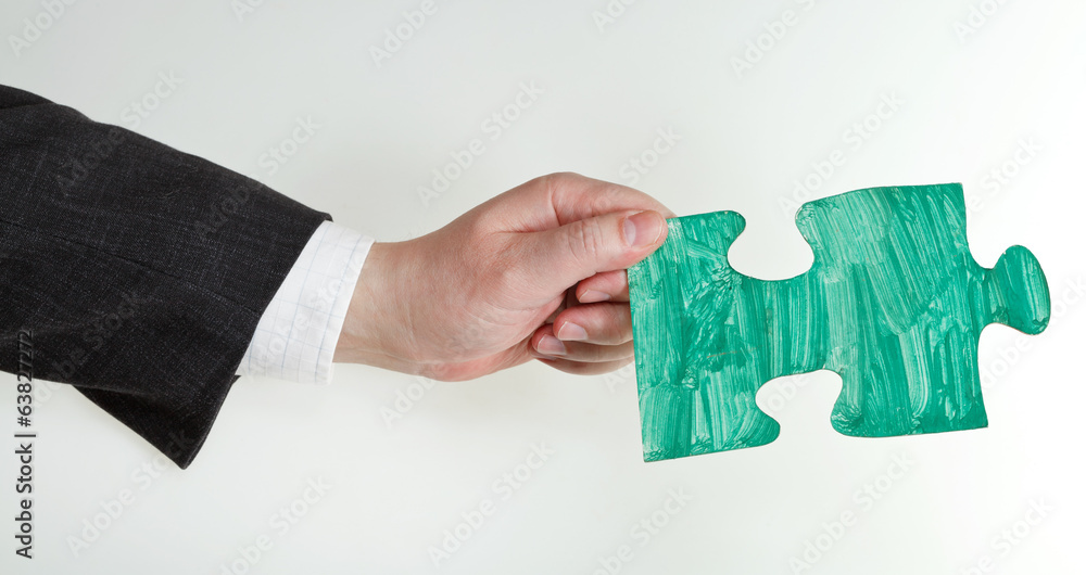 green painted puzzle piece in male hand green painted puzzle piece in male hand