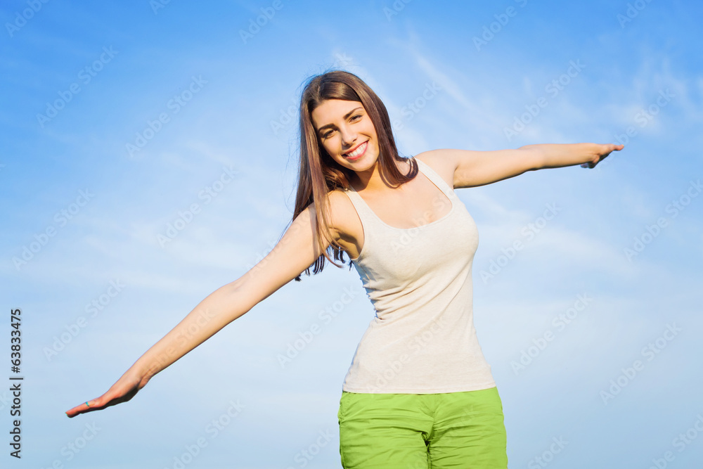 Beautiful happy young woman flying against blue sky Beautiful happy young woman flying against blue sky