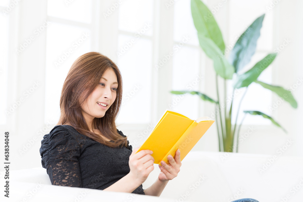部屋で本を読む女性