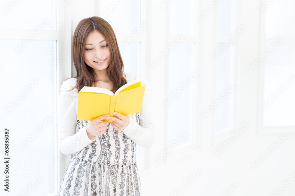 部屋で本を読む女性