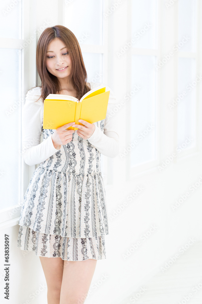 部屋で本を読む女性