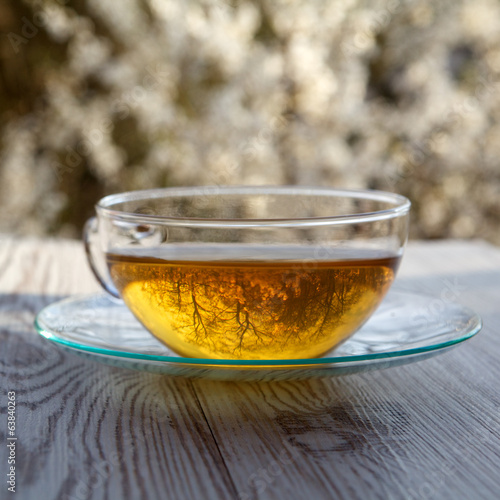 cups of tea on wooden table with blossoming cherry background photo