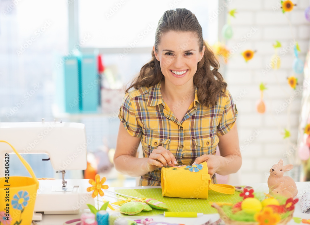 Fototapeta premium Happy young woman making easter decoration in studio