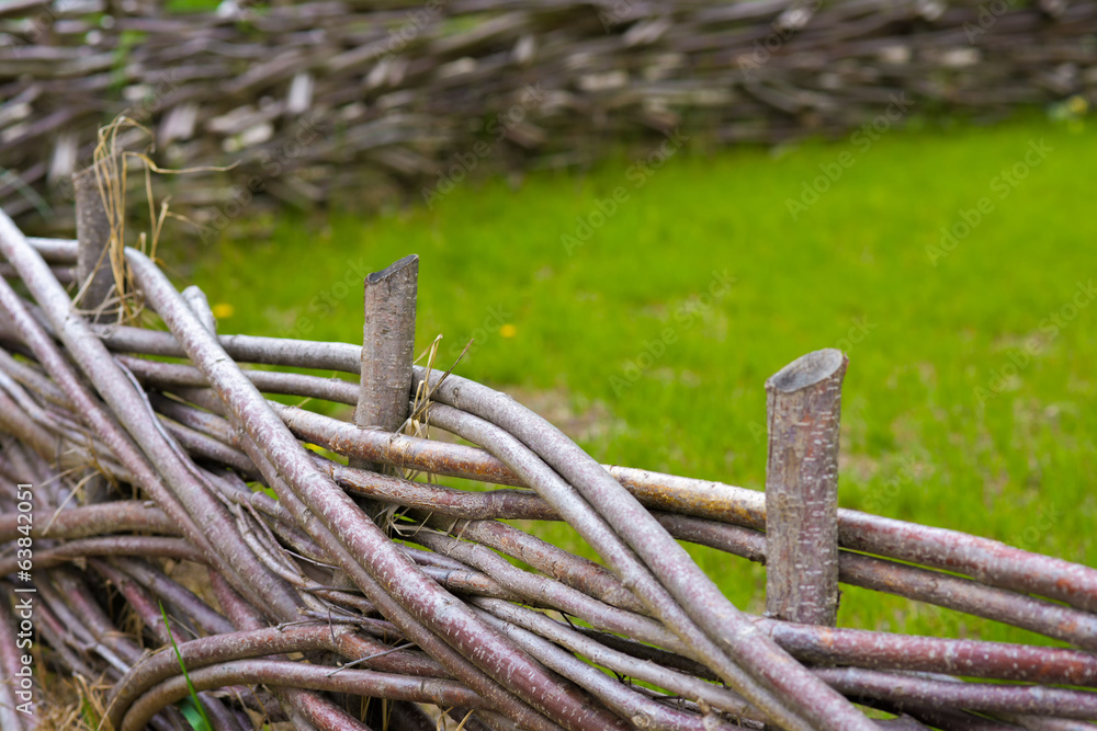 Fototapeta premium Wooden fence braided into a beautiful garden