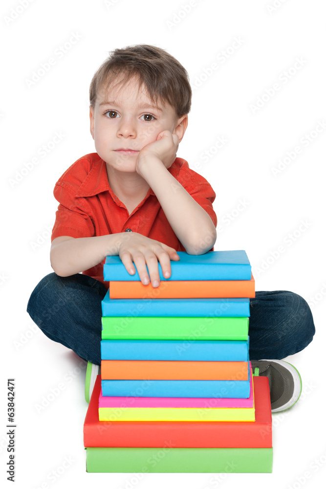 Thoughtful little boy with books