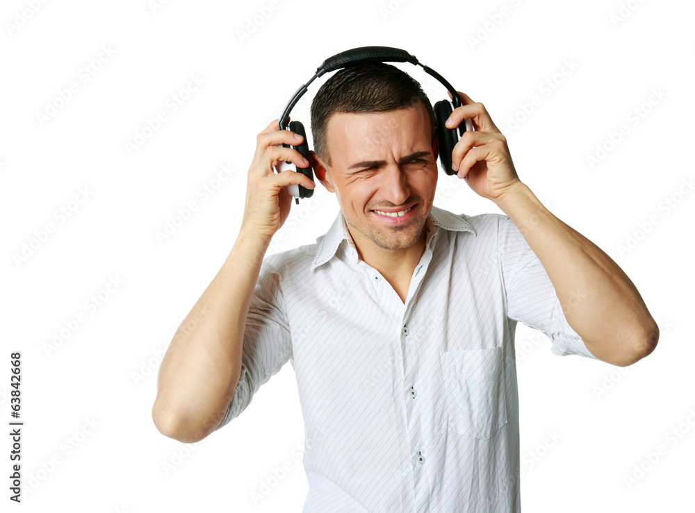 A man not enjoying what he is hearing, listening to music A man not enjoying what he is hearing, listening to music