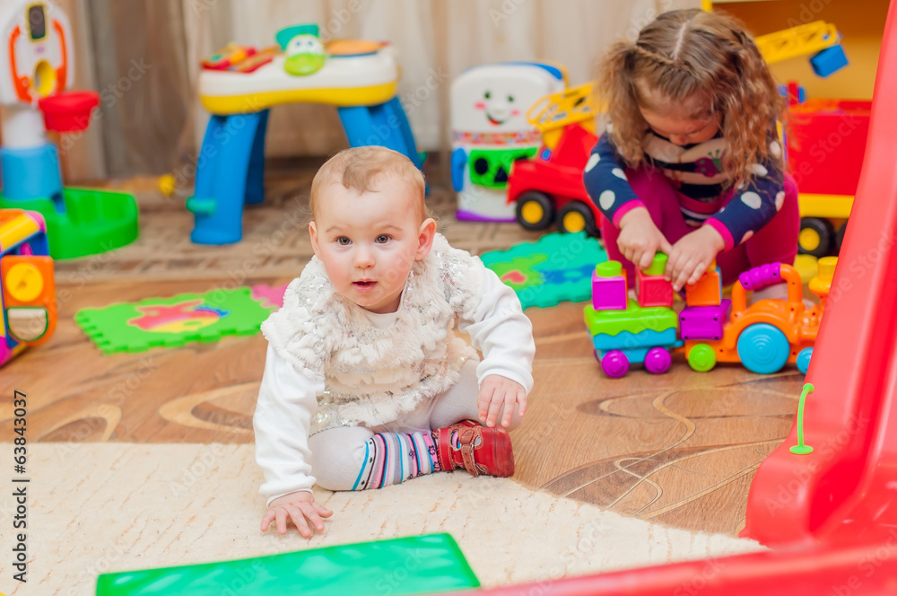 Little girl playing with toys in the playroom Little girl playing with toys in the playroom