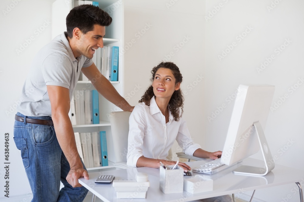 Casual businessman looking at colleagues computer Casual businessman looking at colleagues computer