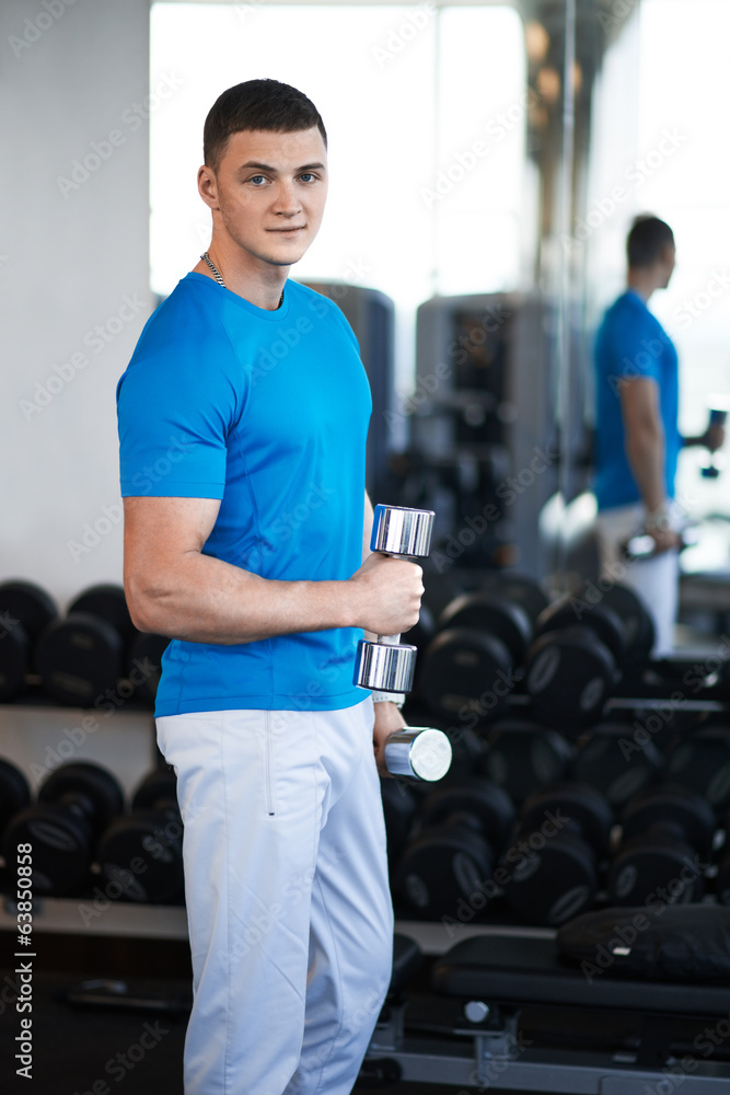 young guy is engaged with a dumbbell young guy is engaged with a dumbbell
