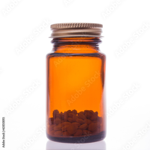 Glass bottle of pills with pills inside