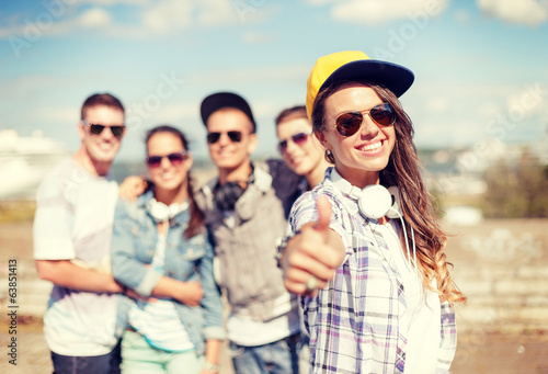 teenage girl with headphones and friends outside