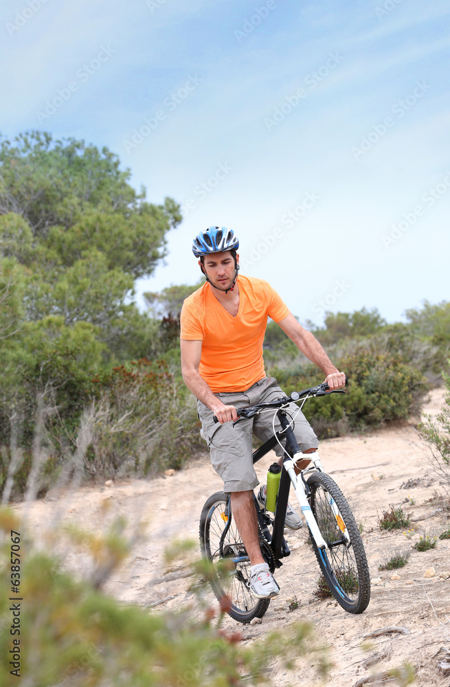 Fototapeta premium Man riding mountain bike on island trail