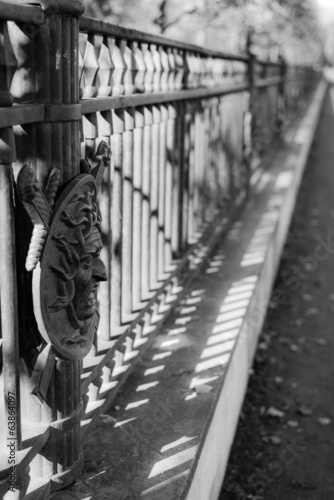 Iron fence with face in garden castle