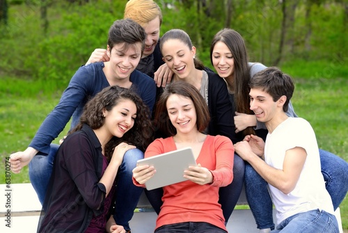 Group of young adults browsing a tablet outside