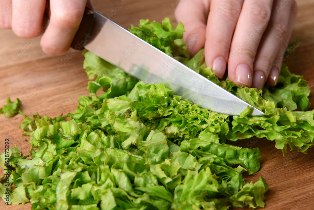 Chopped green lettuce on wooden board close-up Chopped green lettuce on wooden board close-up